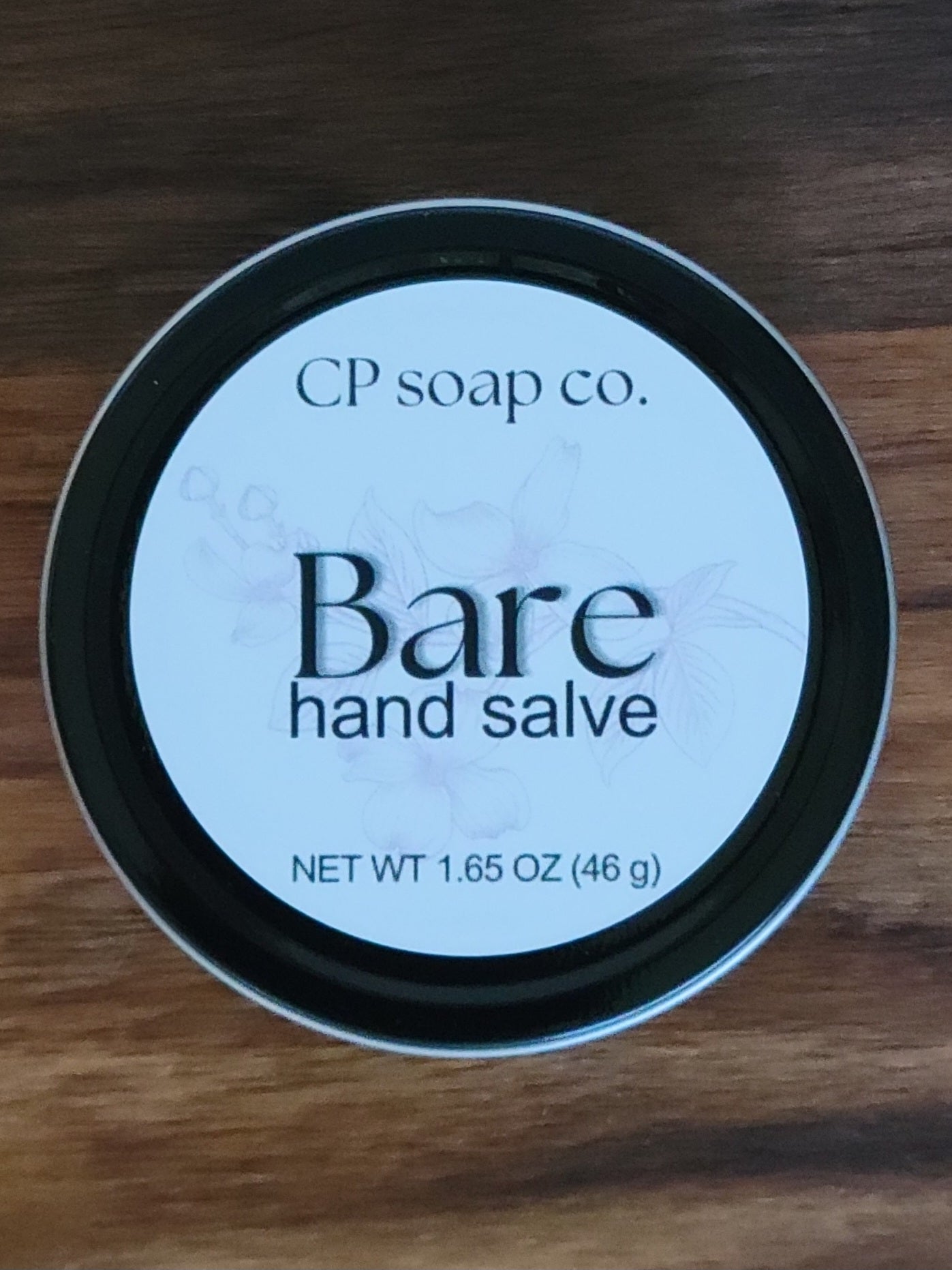 CP Soap Co. Bare hand salve container on a wooden surface