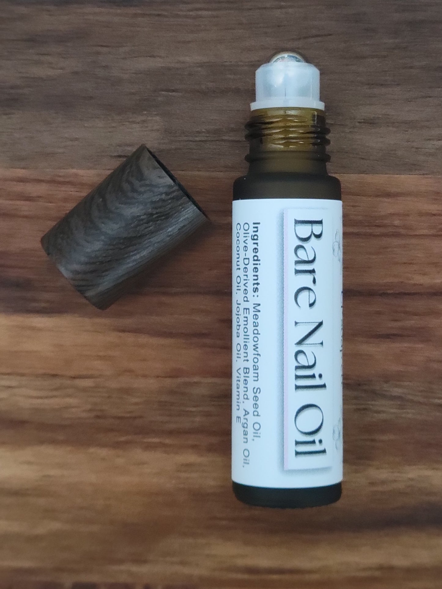 Bottle of Bare Nail Oil on a wooden surface