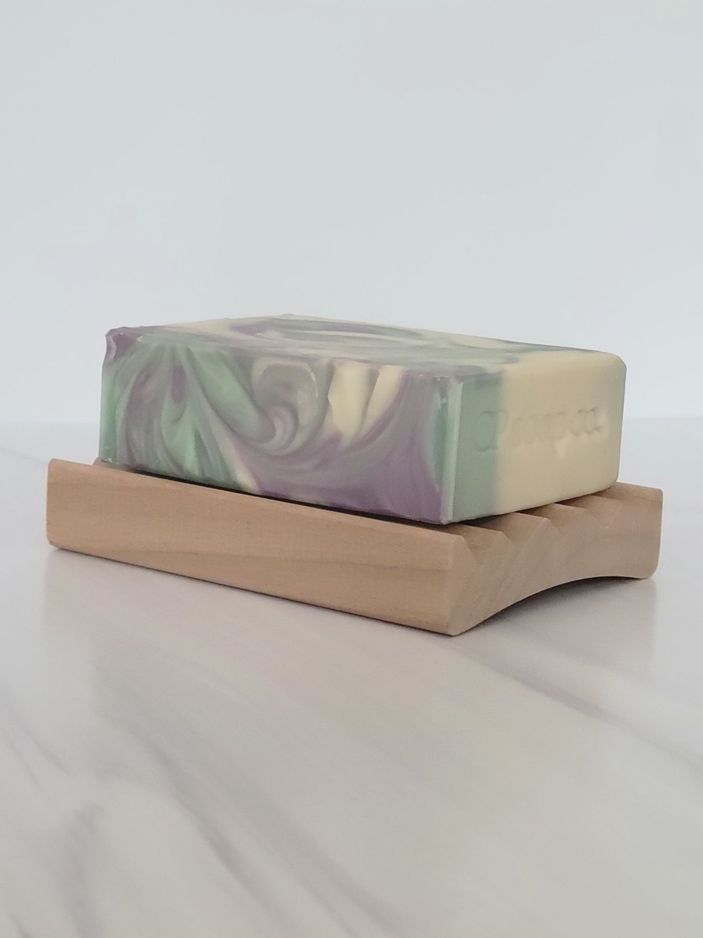 Poplar wood soap dish with the Dream Bar cold process soap swirled top view showing the curve of the dish