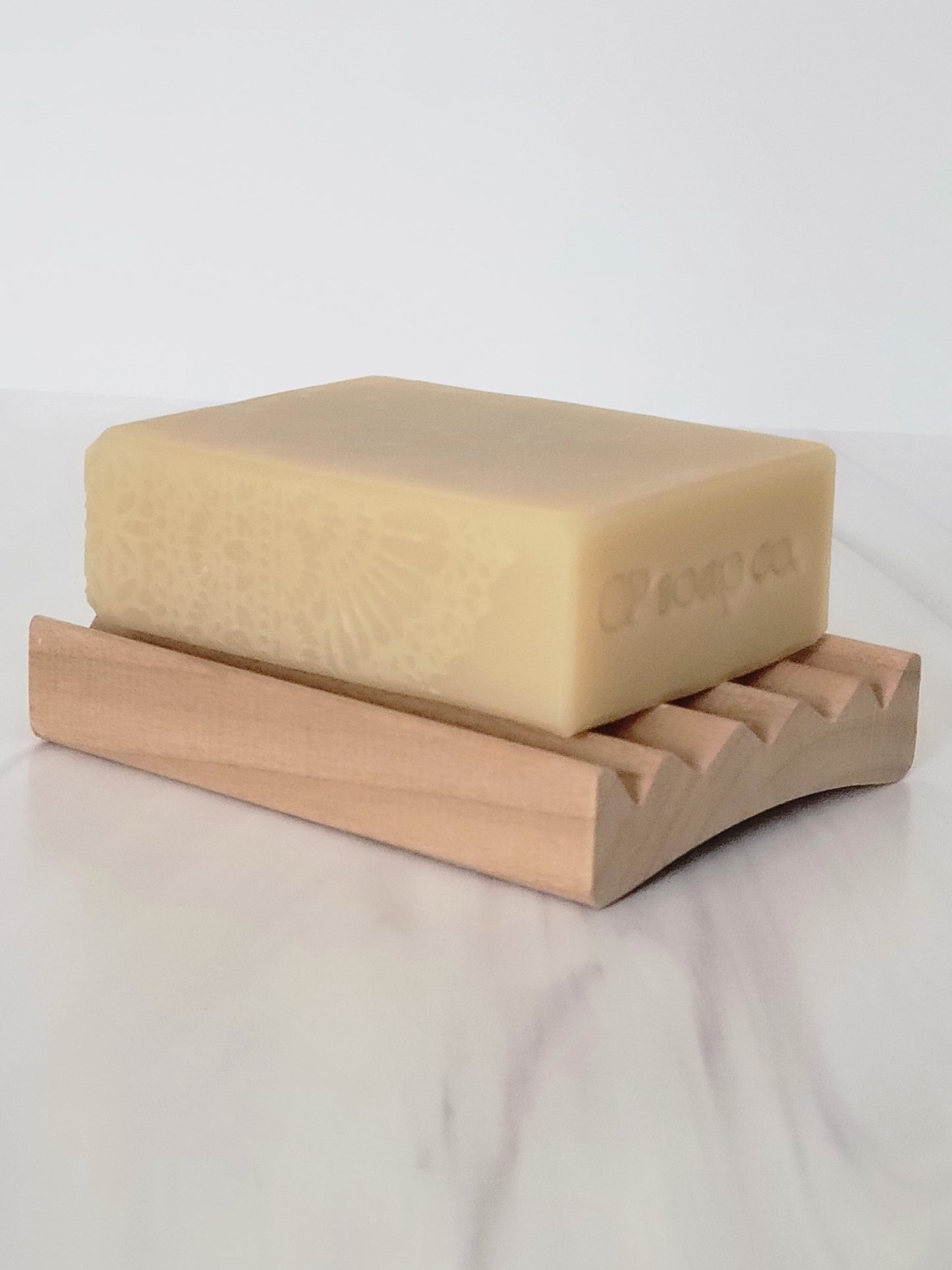 Poplar wood soap dish with the Sunday Blend Bar cold process soap lace top view showing the curve of the dish