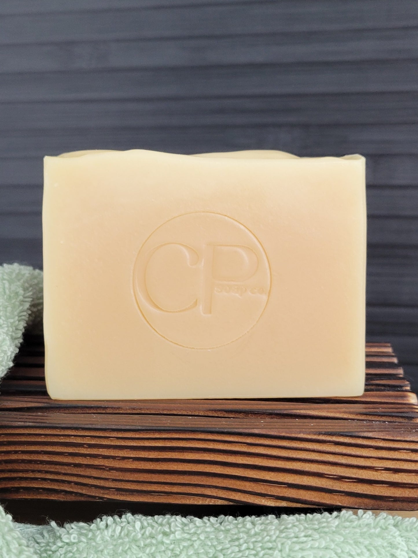 Bar of soap with a logo on a wooden surface