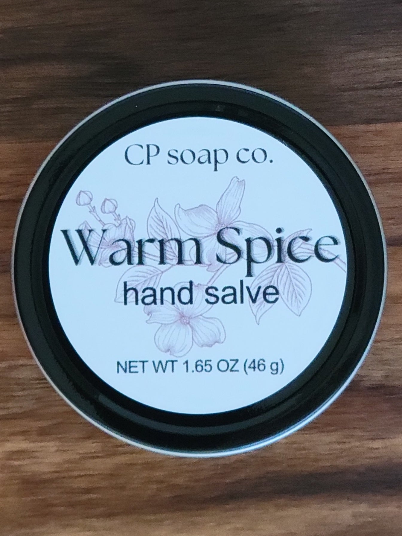 CP Soap Co. Warm Spice hand salve container on a wooden surface