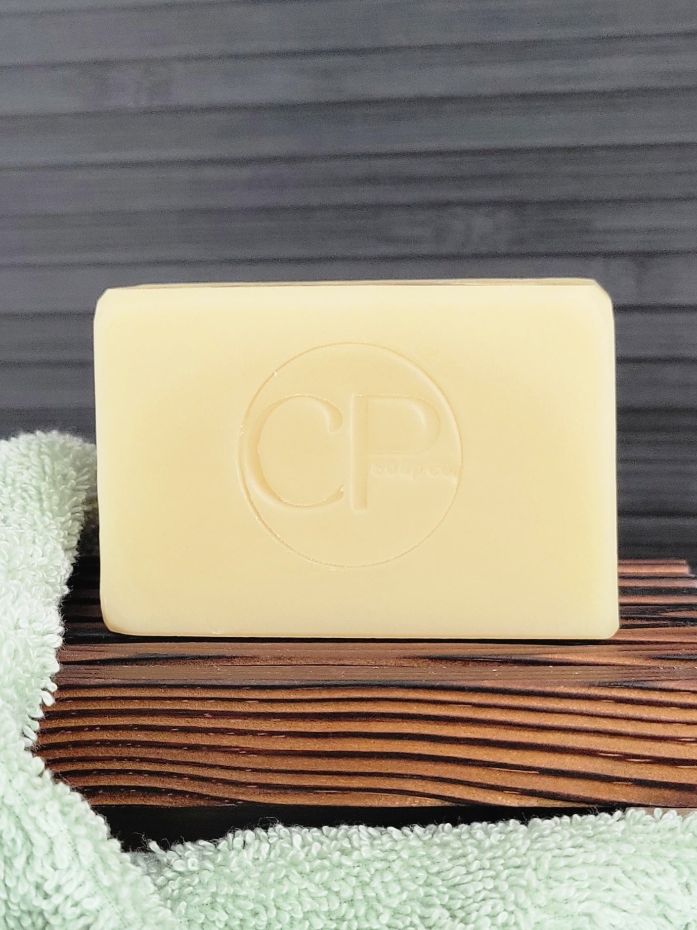 Bar of soap with a logo on a wooden surface