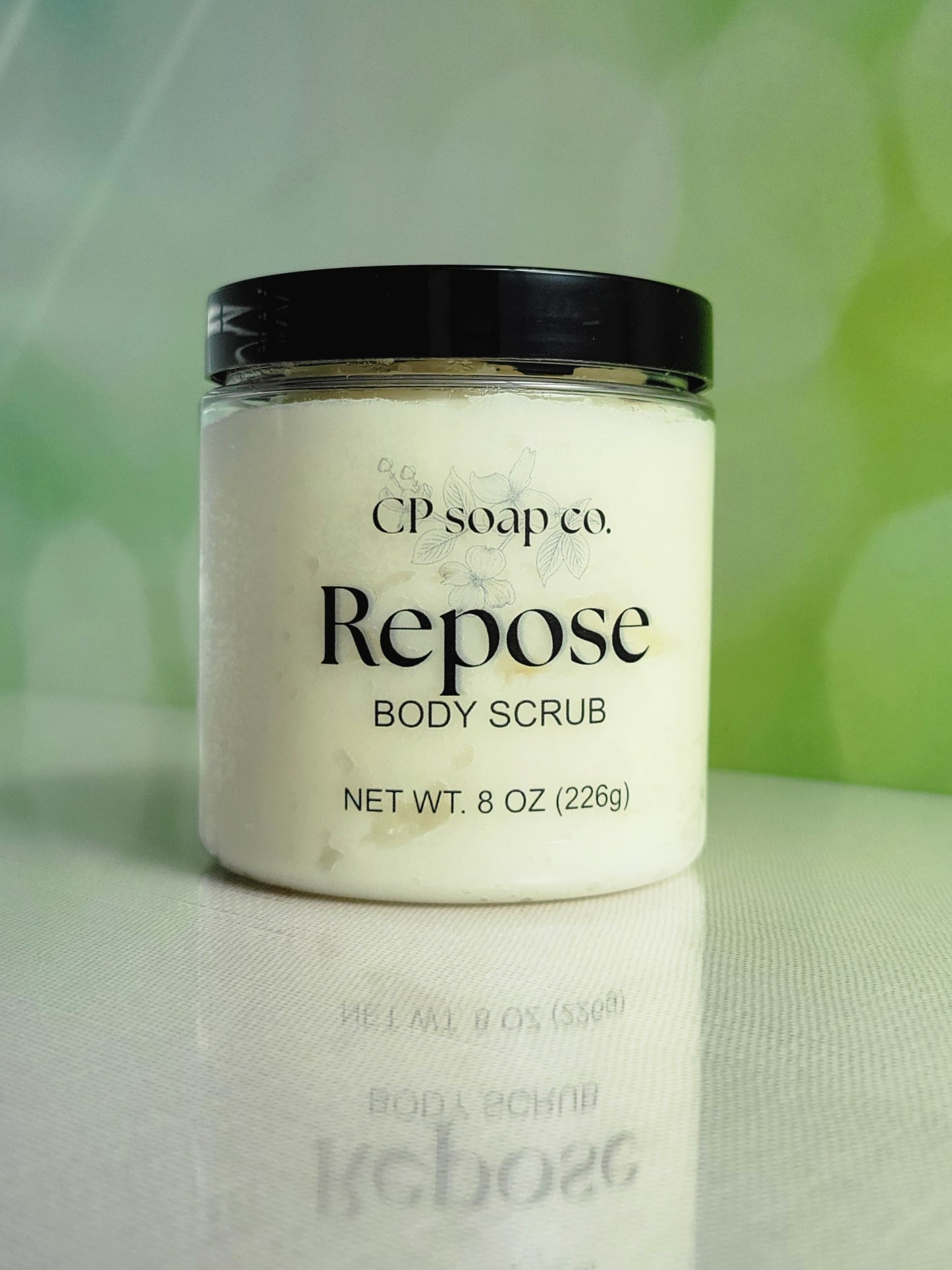 Jar of CP Soap Co. Repose Body Scrub with a black lid on a light background