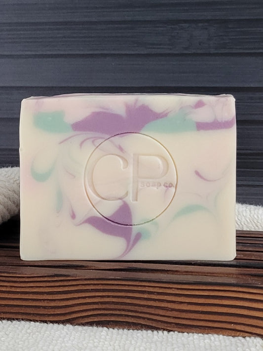 Colorful soap bar with 'CP' logo on a wooden surface